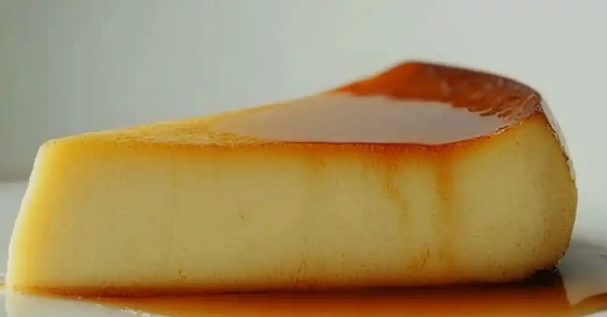 A modern presentation of quesillo topped with caramel sauce, served on a white plate with garnishes.