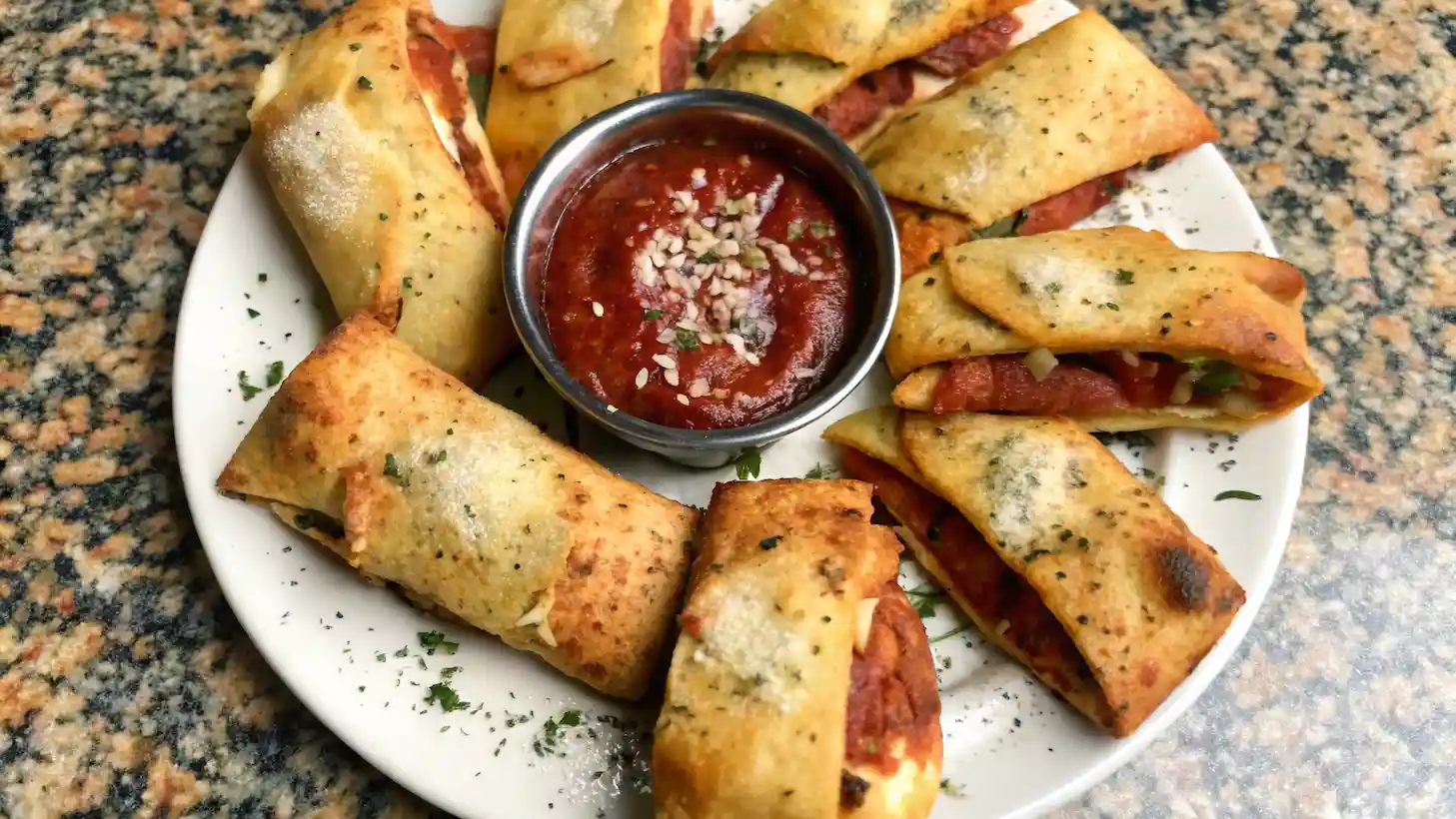 A freshly baked Italian Stromboli with a golden crust, sliced open to reveal layers of cheese, pepperoni, and ham, served with marinara.